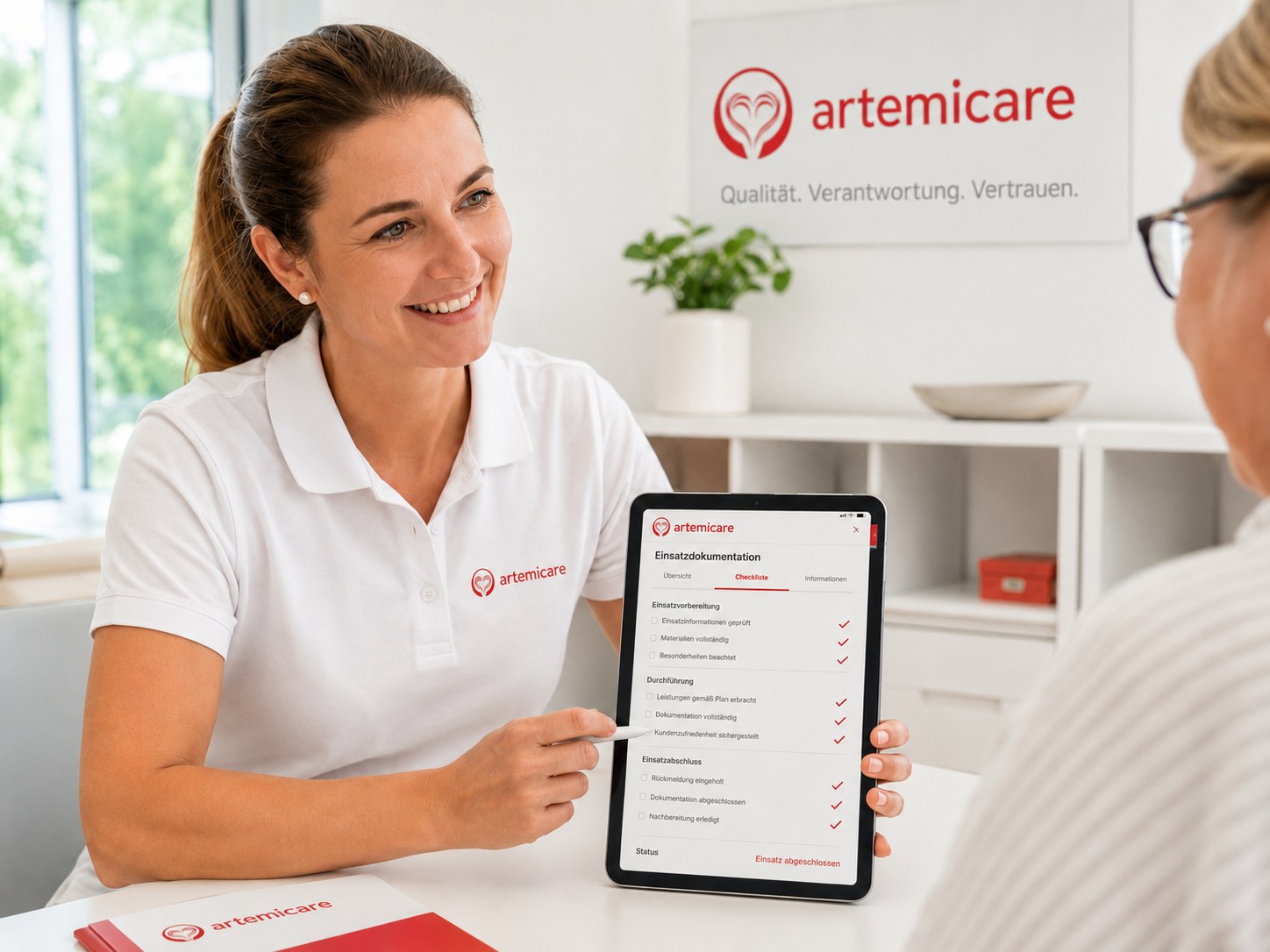 artemicare Mitarbeiterin erklärt Einsatzdokumentation auf einem Tablet